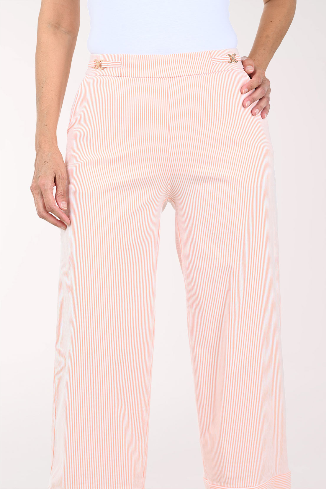 Person wearing light pink pants on a white background