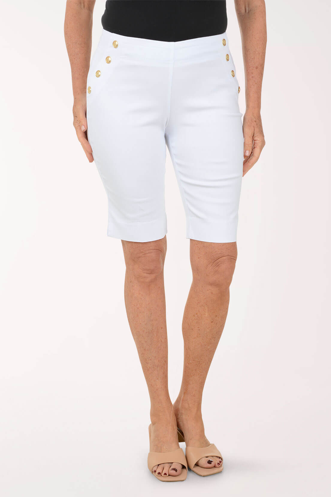 White shorts with gold buttons worn by a person on a white background