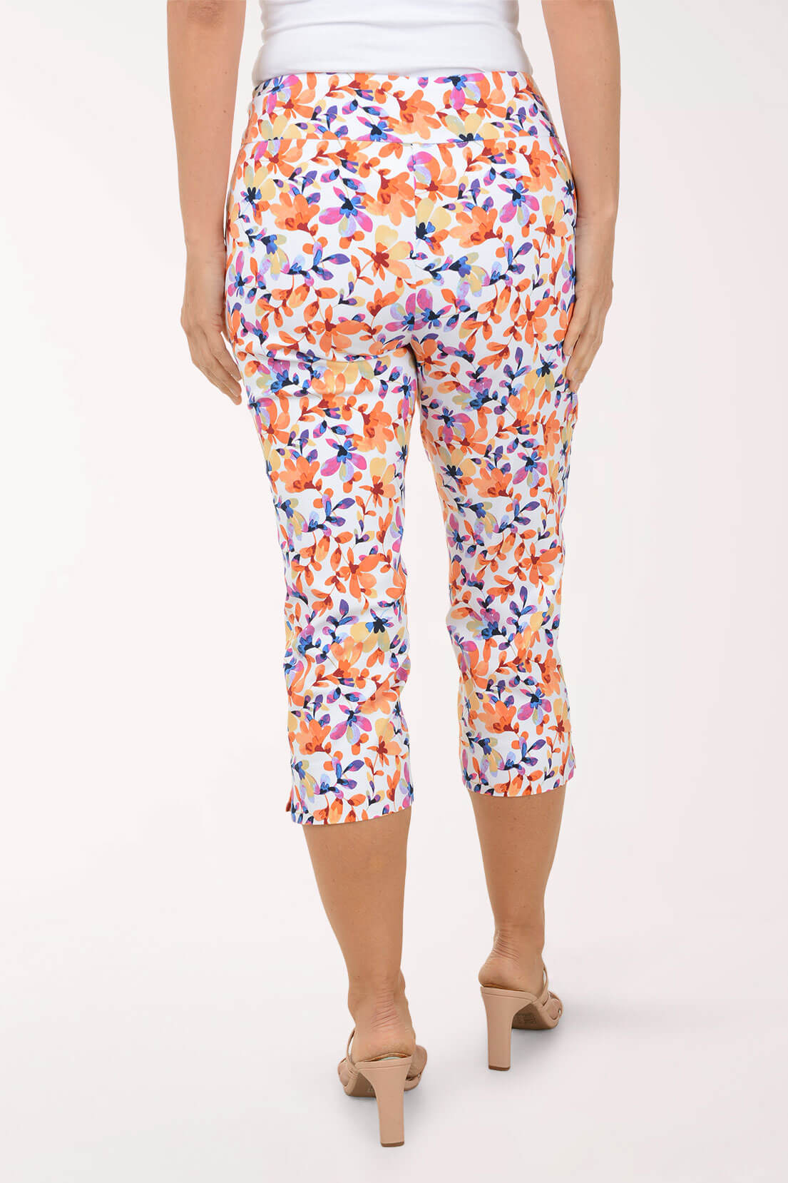 Colorful floral capri pants worn by a person on a white background