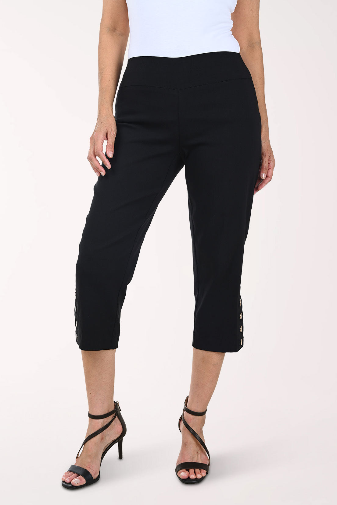 Person wearing black capri pants on a white background
