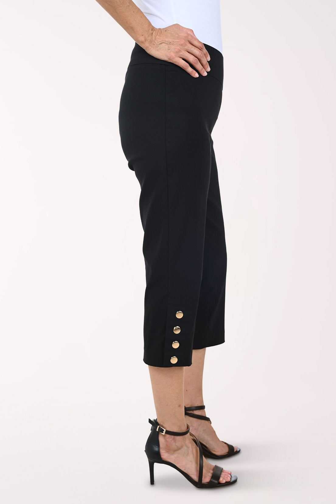 Person wearing black capri pants on a white background