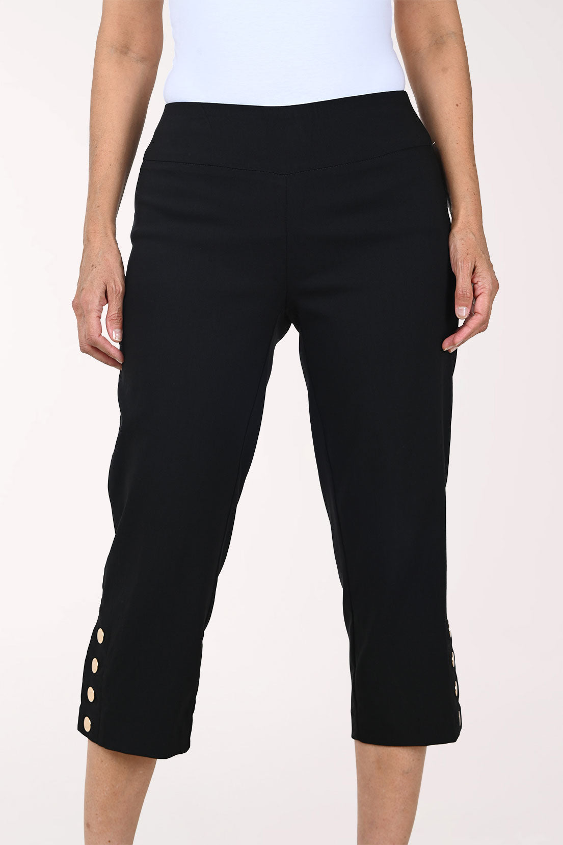 Person wearing black capri pants on a white background