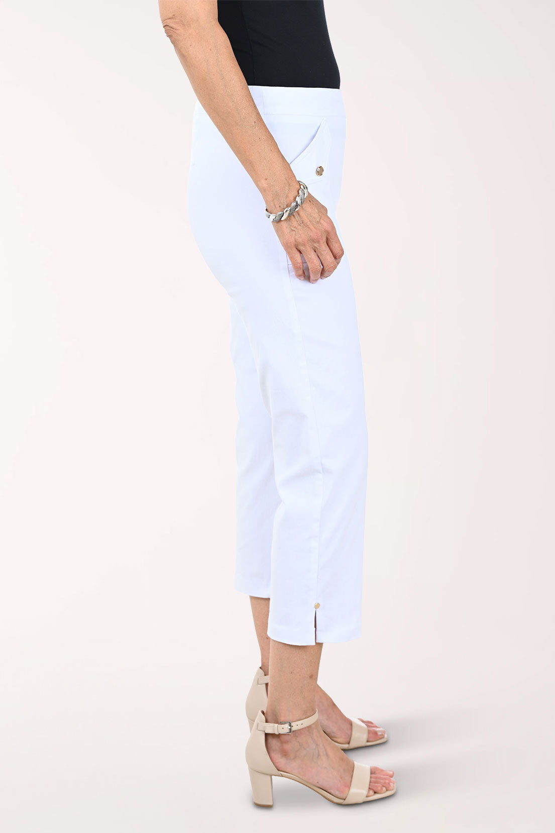 White capri pants worn by a person on a white background