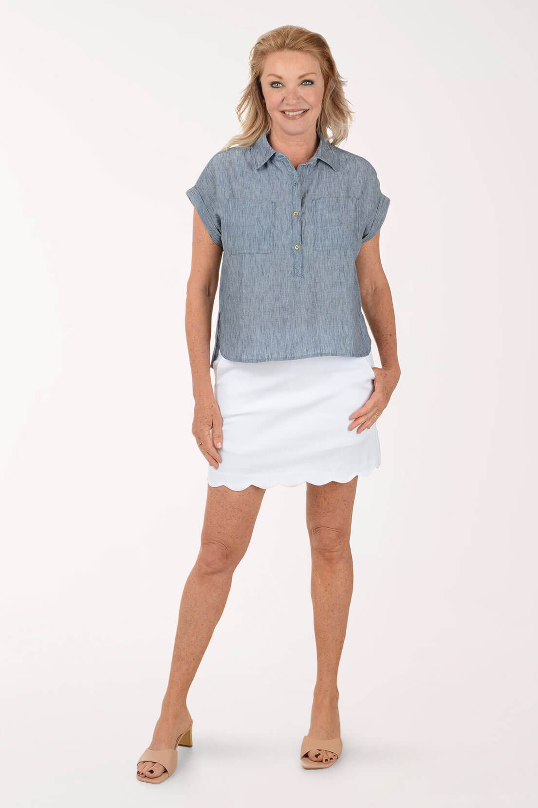 Woman wearing a blue shirt and white skirt on a white background