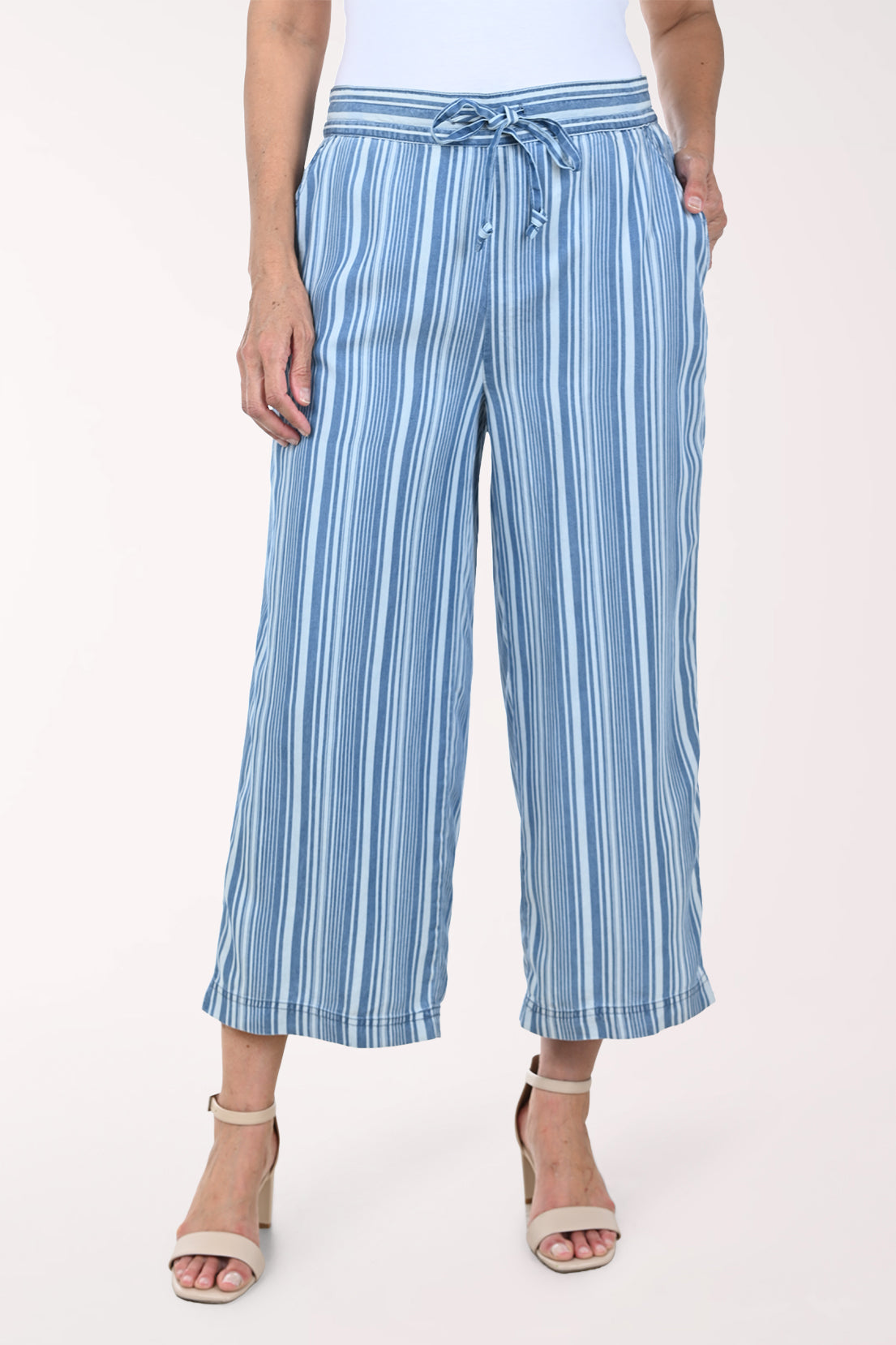 Woman wearing blue striped patterned pants on a white background