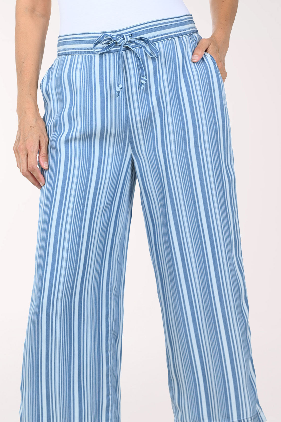 Woman wearing blue striped patterned pants on a white background