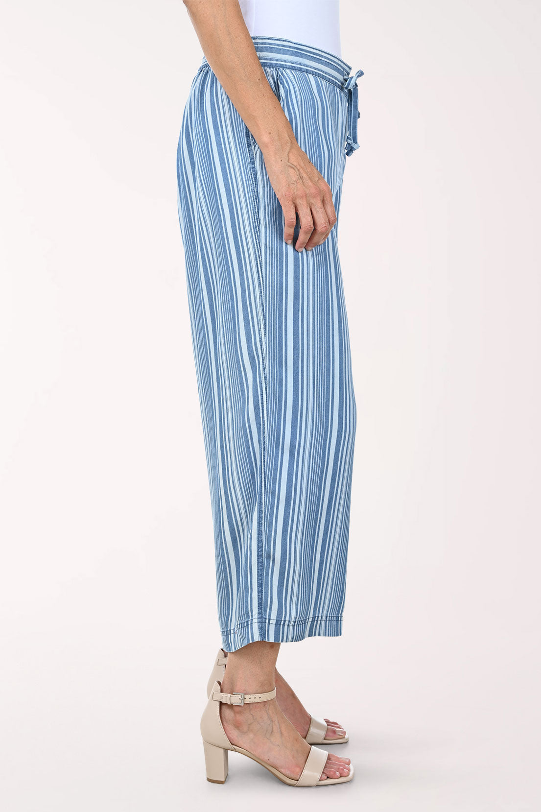 Woman wearing blue striped patterned pants on a white background