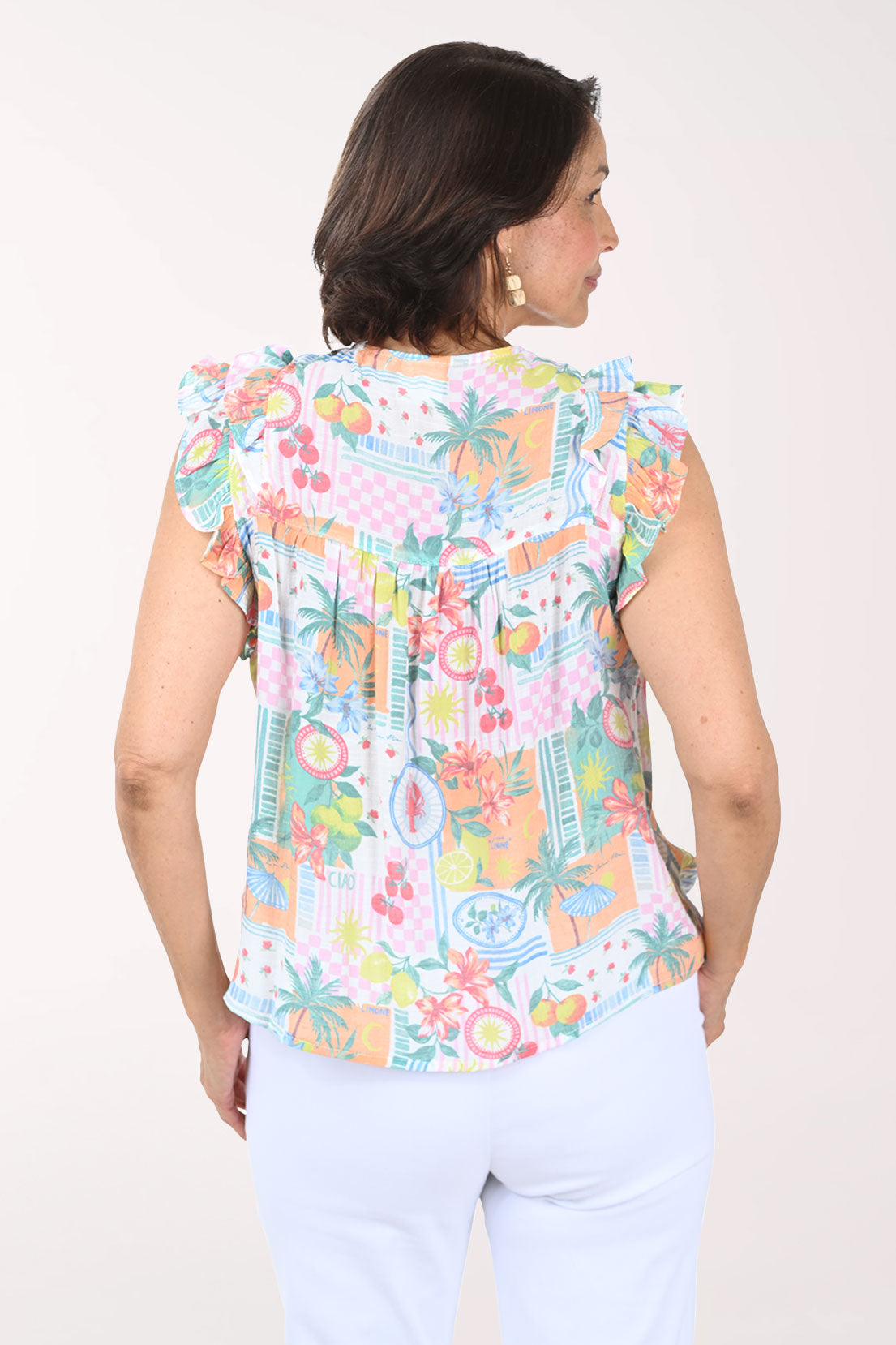 Woman wearing a colorful sleeveless top with a white background