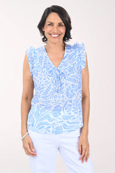 Woman wearing a blue floral sleeveless top against a white background