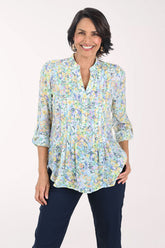 Woman wearing a floral blouse with a plain background