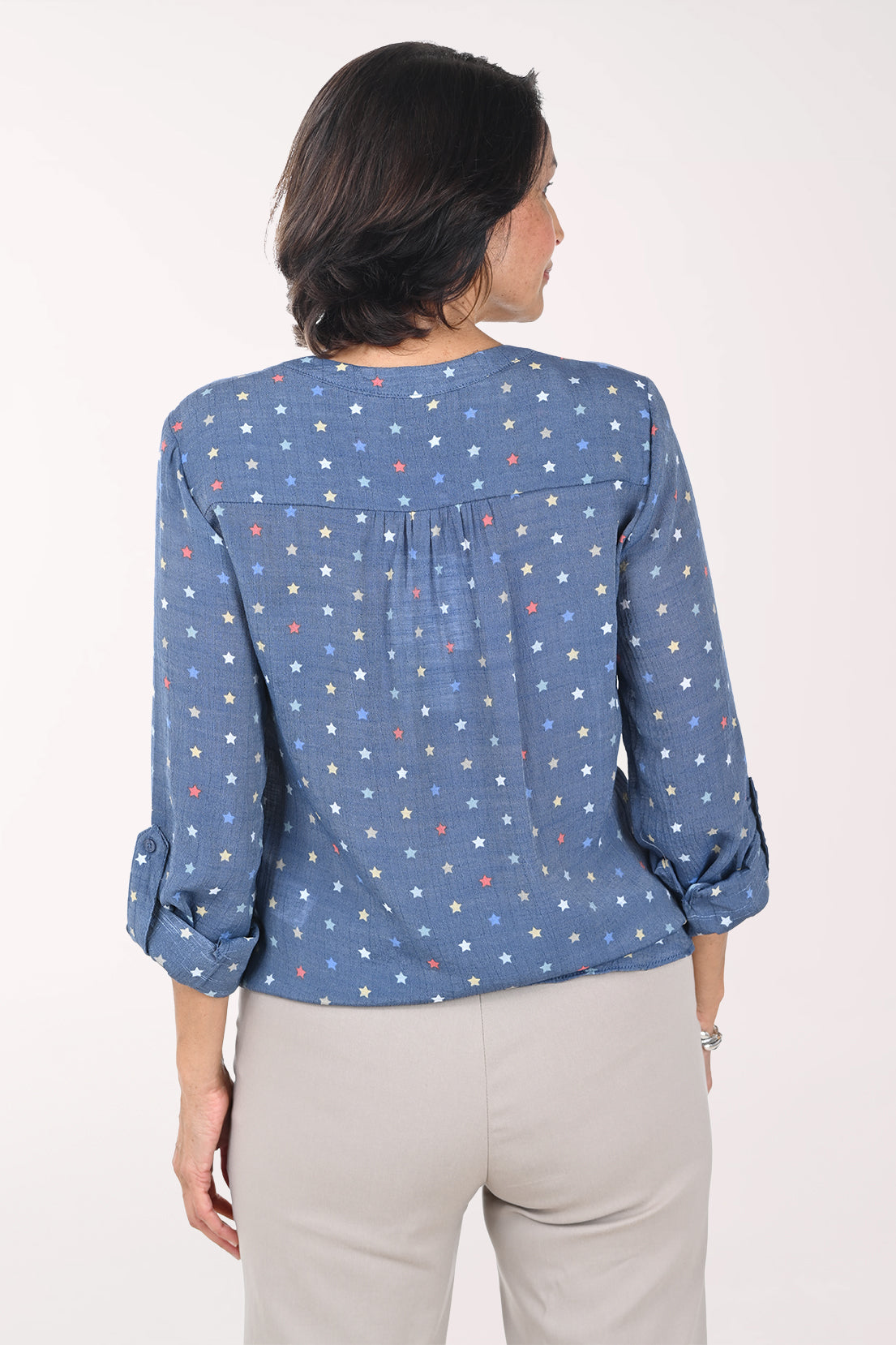 Woman wearing a blue patterned blouse with a white background