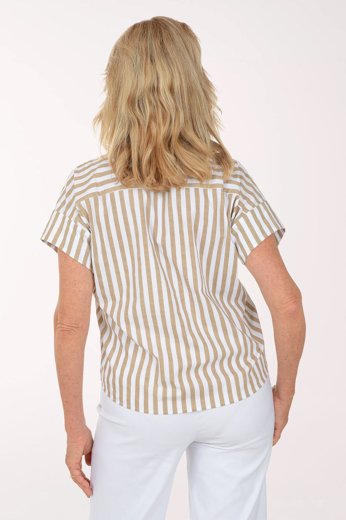 Woman wearing a striped shirt and white pants on a white background