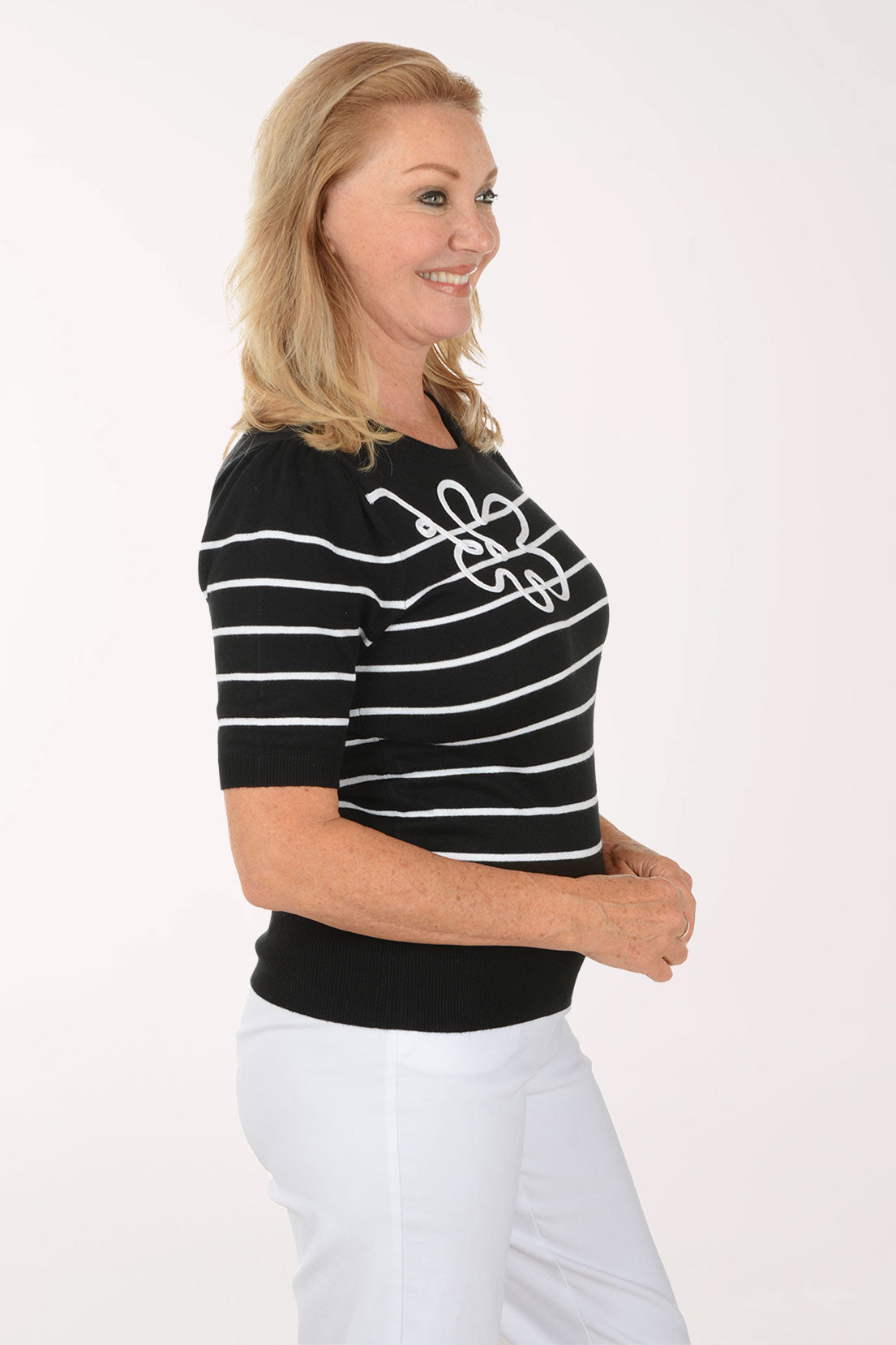 Woman wearing a black and white striped shirt with butterfly designs on a white background
