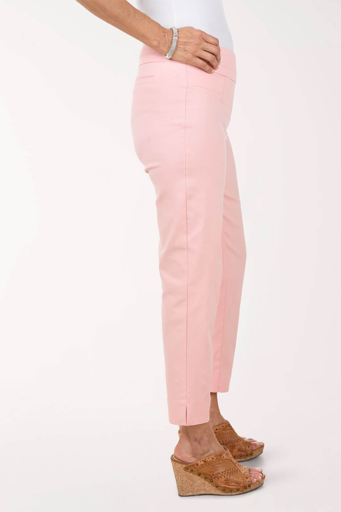 Person wearing light pink pants on a white background - side shot