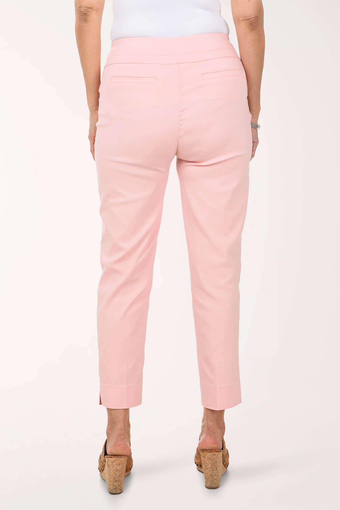 Person wearing light pink pants on a white background - back shot