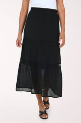Black layered skirt worn by a person on a white background