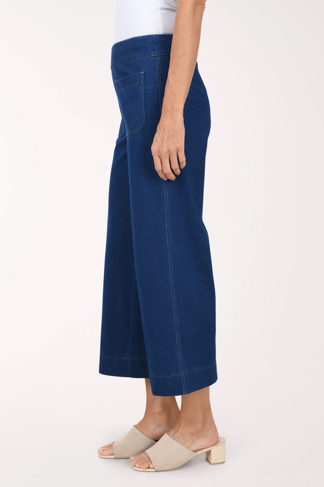 A side view of medium wash wide leg cropped pull-on jeans showing the cropped length.