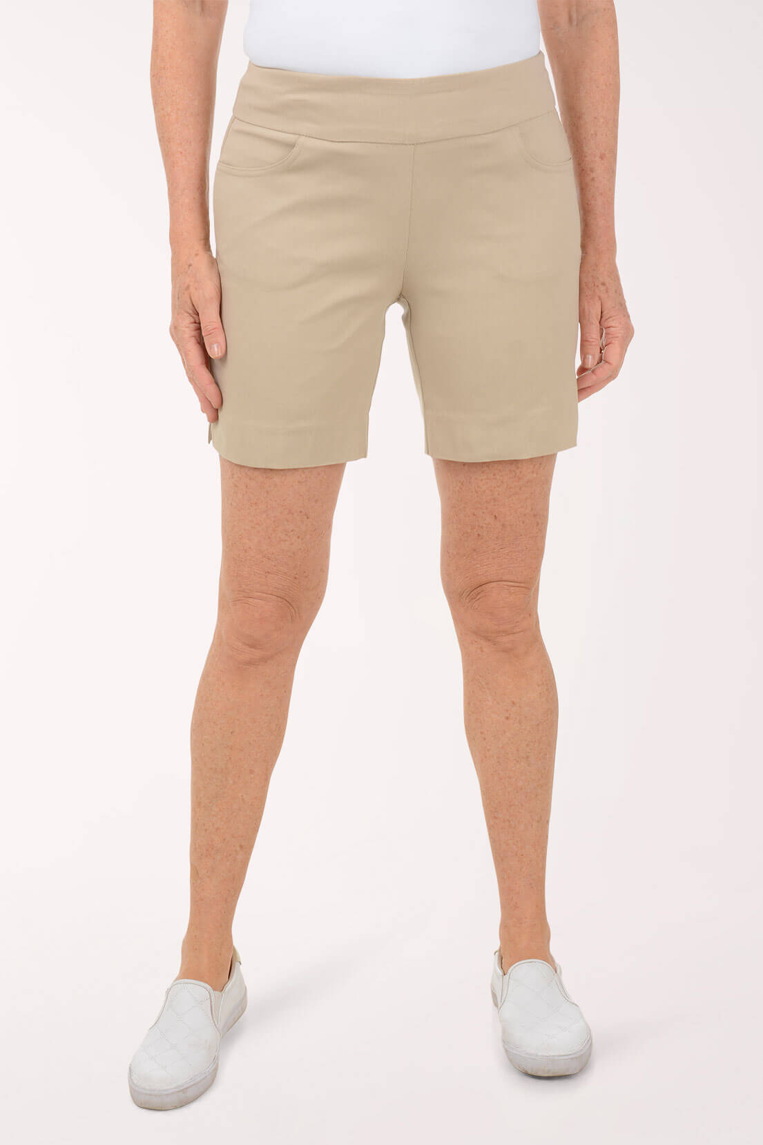 Person wearing beige shorts on a white background