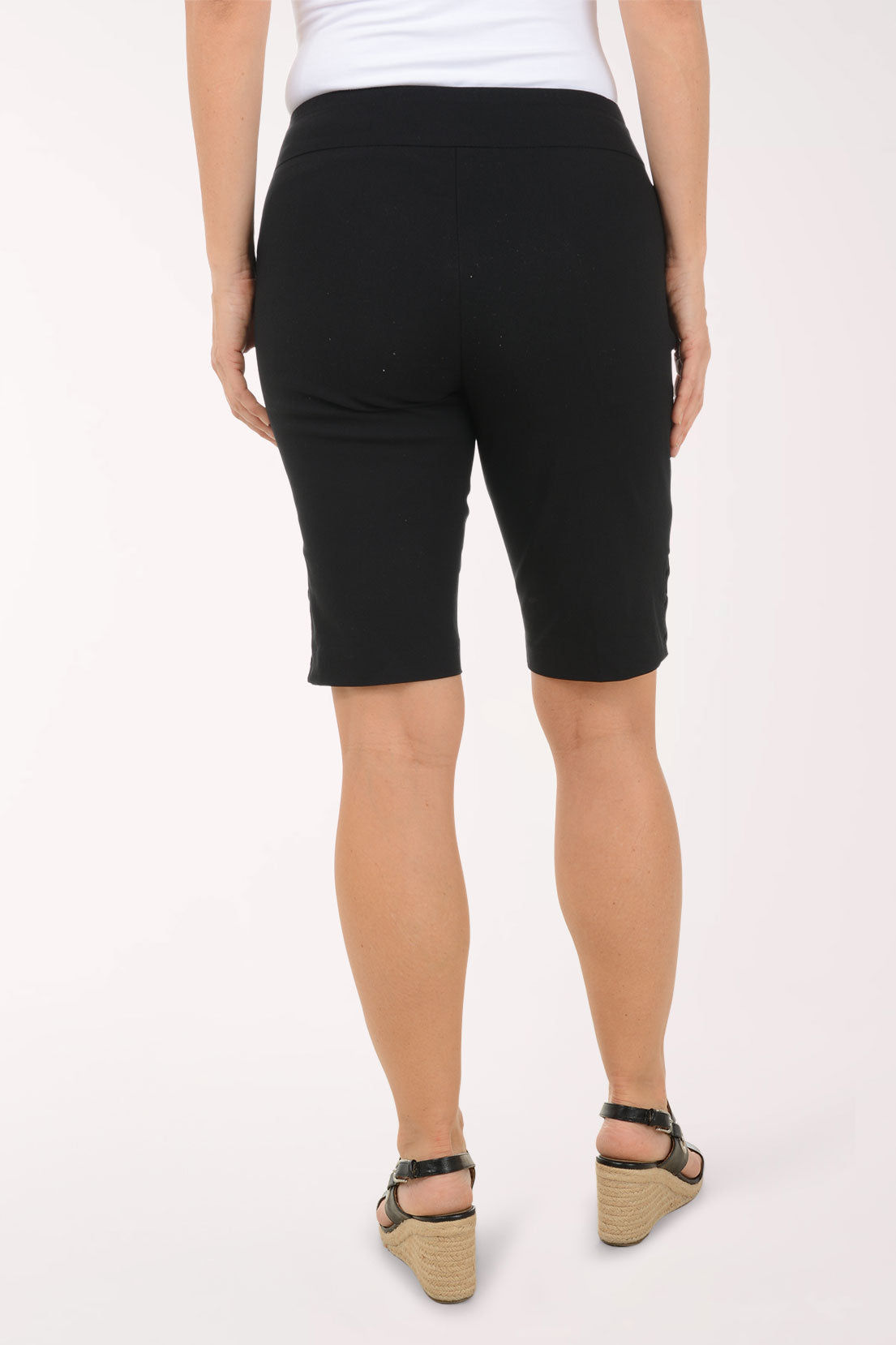 A woman wearing black bermuda shorts.