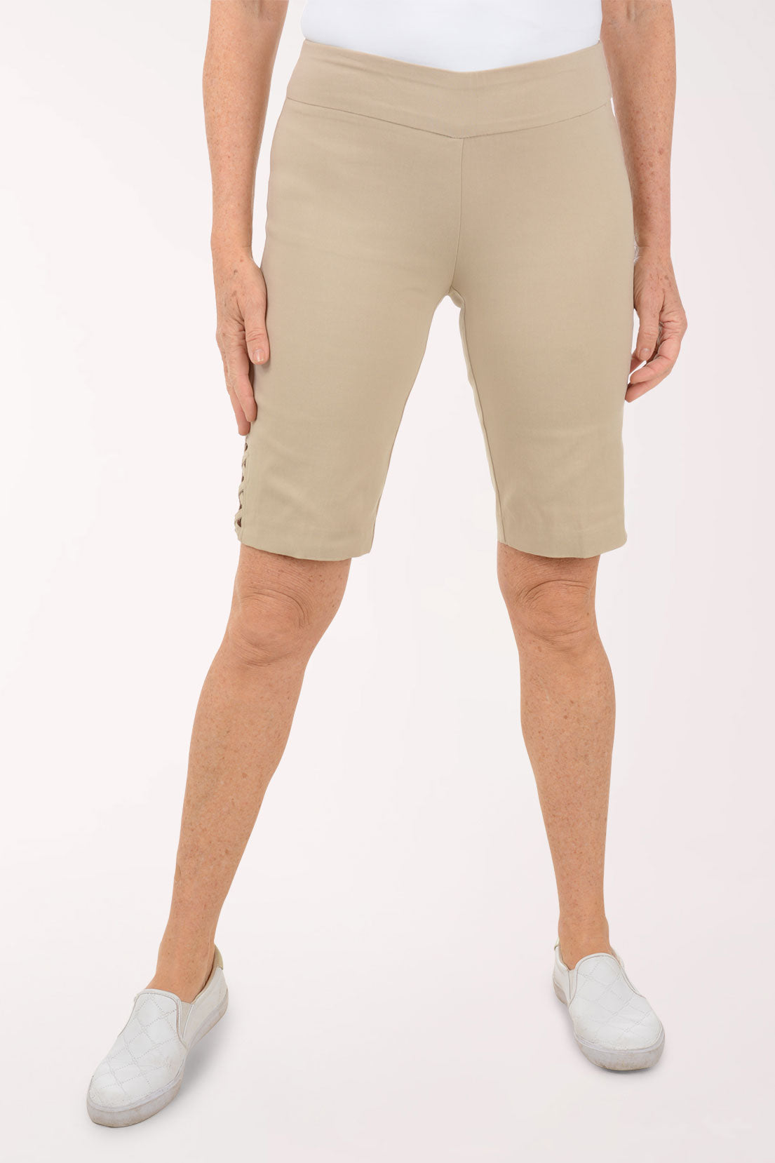 A woman wearing brown bermuda shorts.