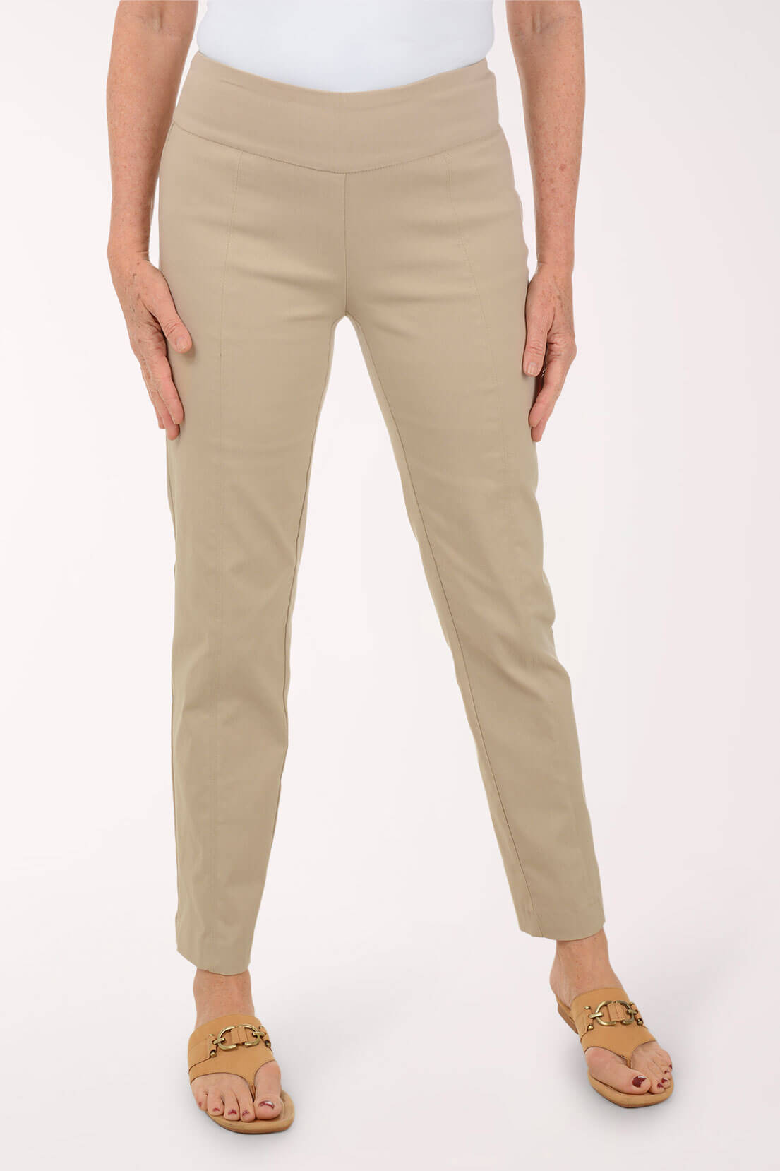 Beige pants worn by a person on a white background