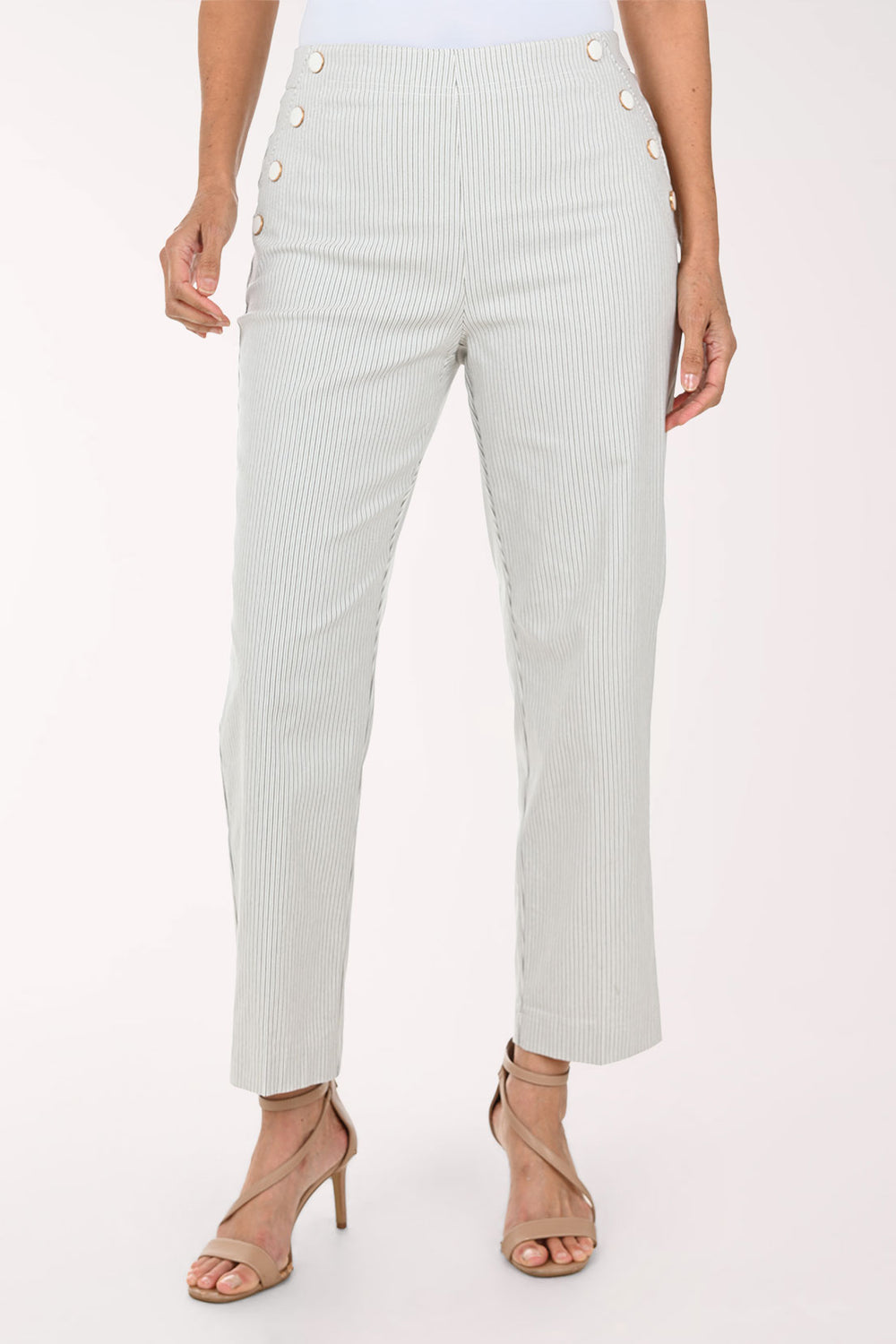 A model wearing light sage green pinstriped trousers with decorative gold buttons on the sides, paired with beige strappy high-heeled sandals against a plain white background.