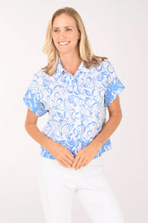 Woman wearing a blue and white patterned blouse on a white background