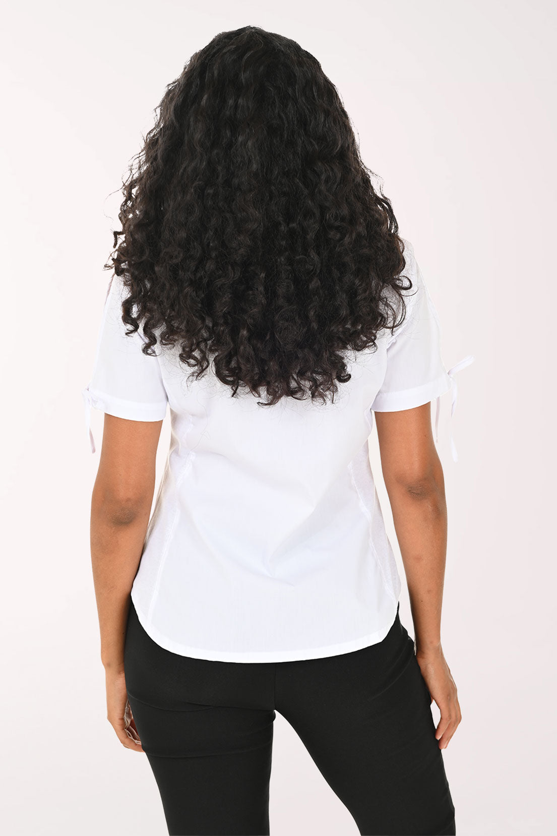 Woman wearing a white short-sleeve shirt and black pants on a white background