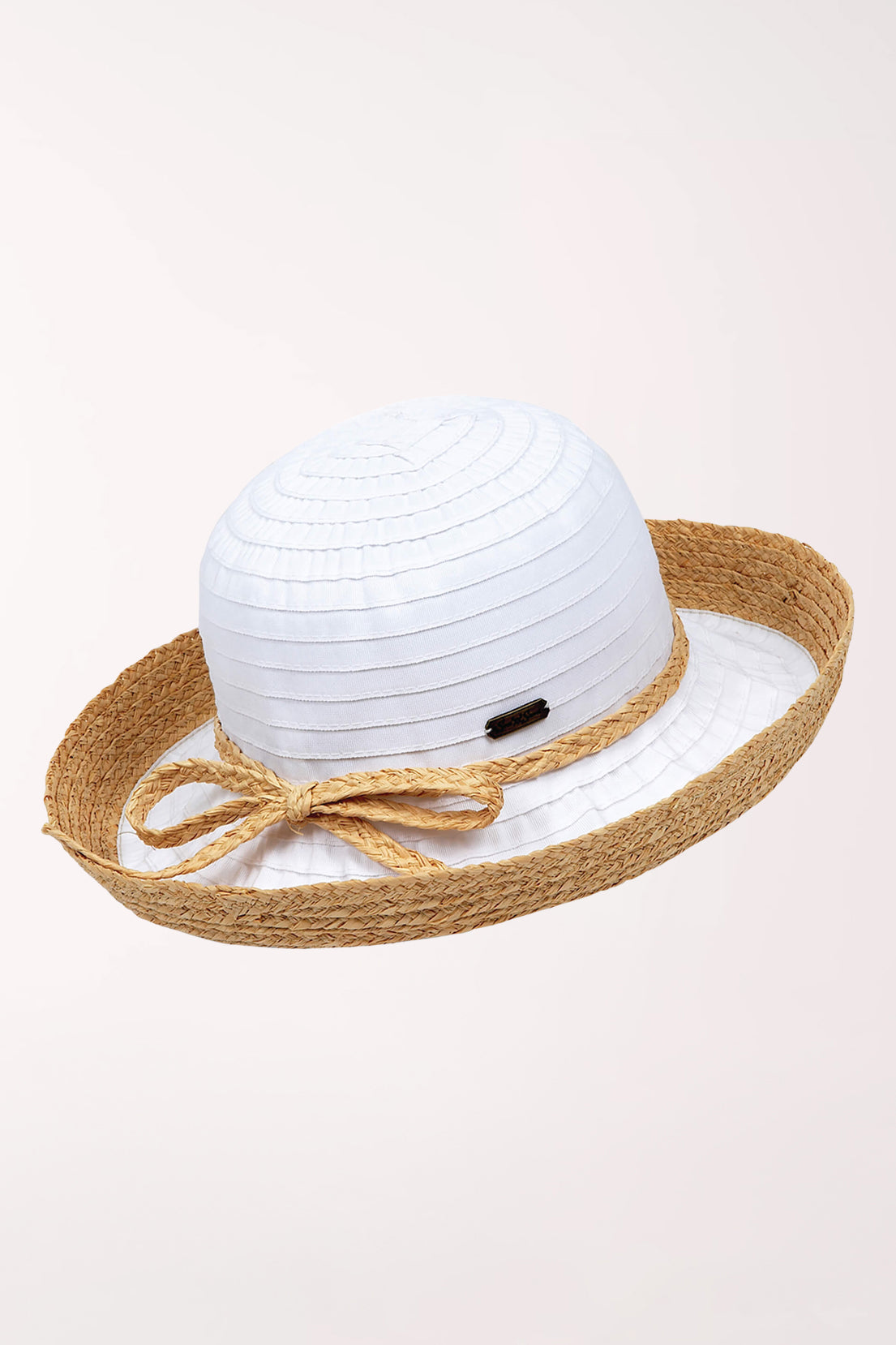 White sun hat with a brown ribbon and bow on a light pink background