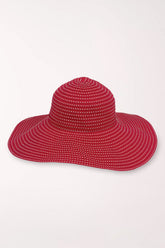 Red sun hat with white polka dots on a light gray background
