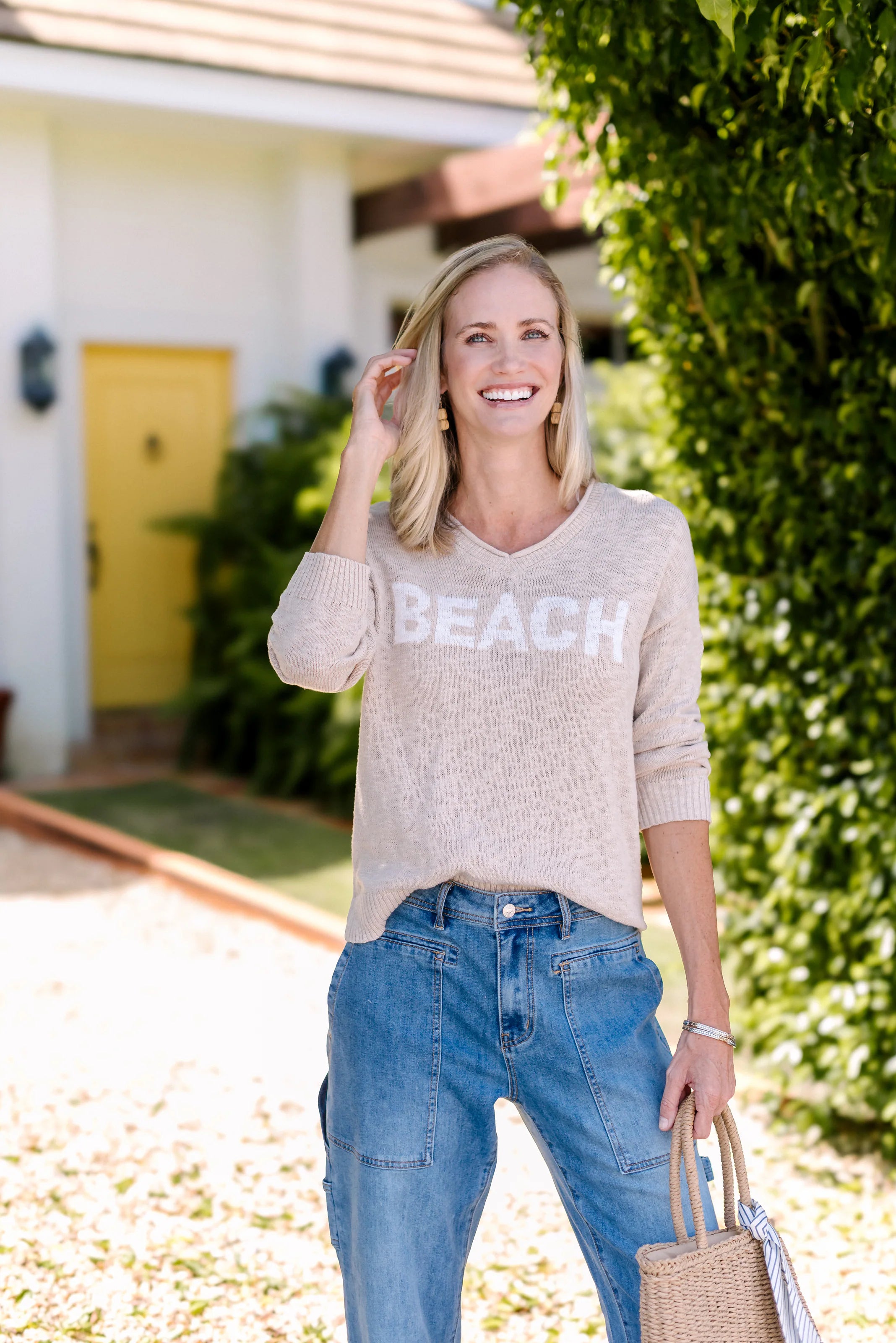 Close-up of a woman wearing a taupe BEACH sweater.