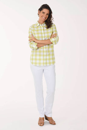 Woman wearing a yellow checkered shirt and white pants on a white background