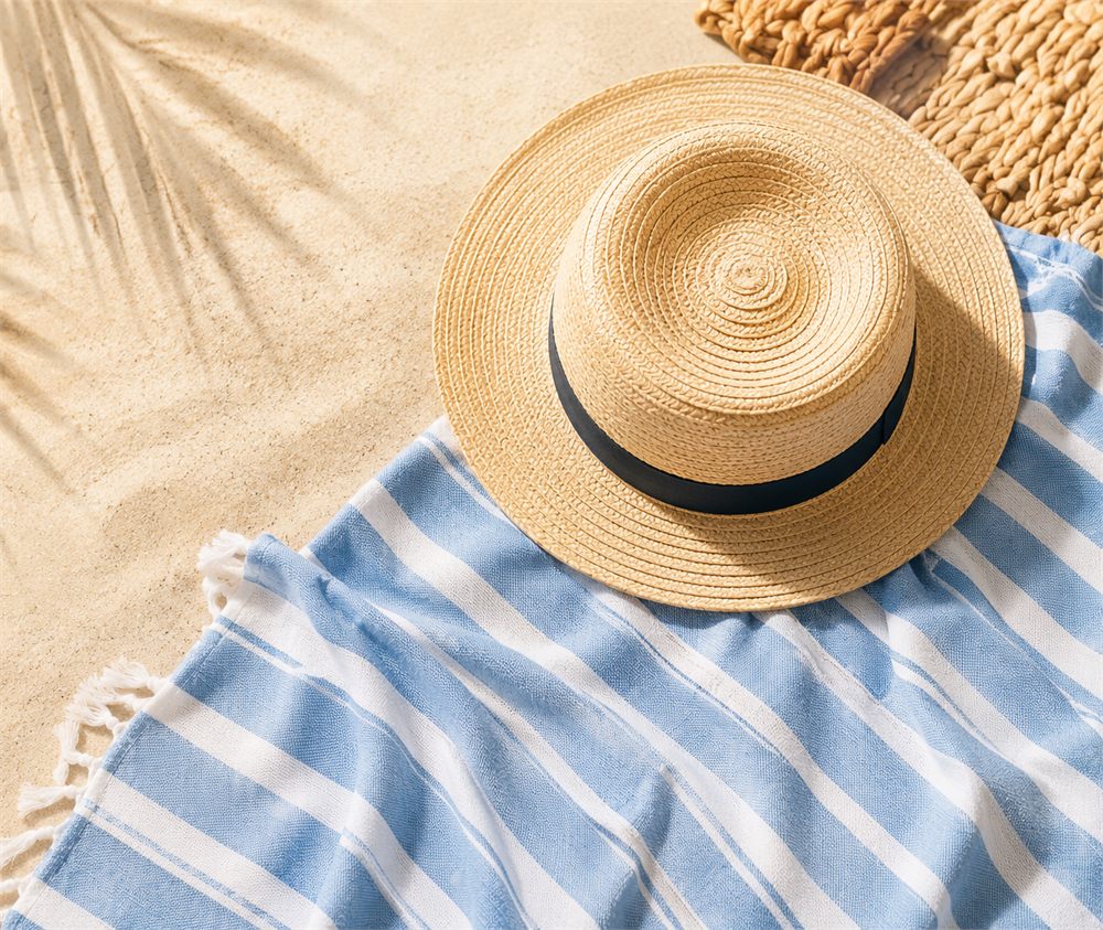 Sun hat on a blue striped beach towel